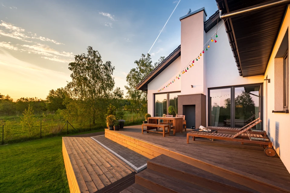 Terrasse extérieure moderne en bois avec mobilier de jardin, chaises longues et table à manger
