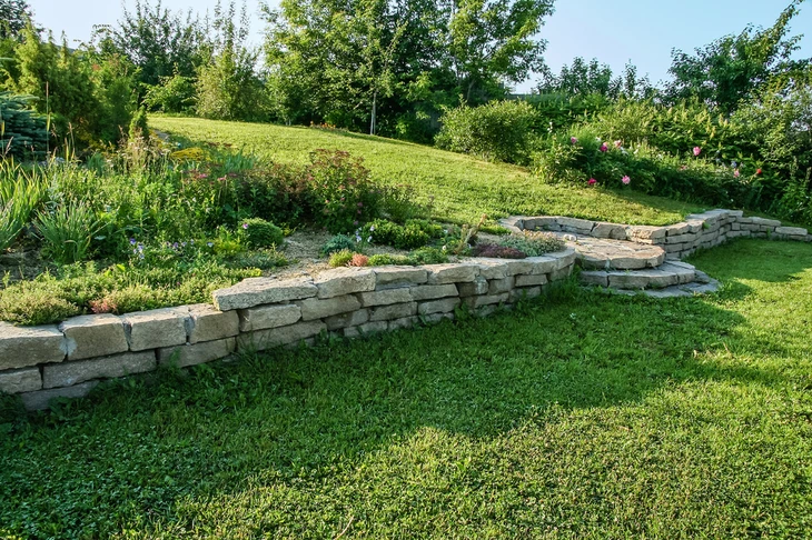 Jardin paysager en terrasses avec murets de soutènement en pierre naturelle calcaire