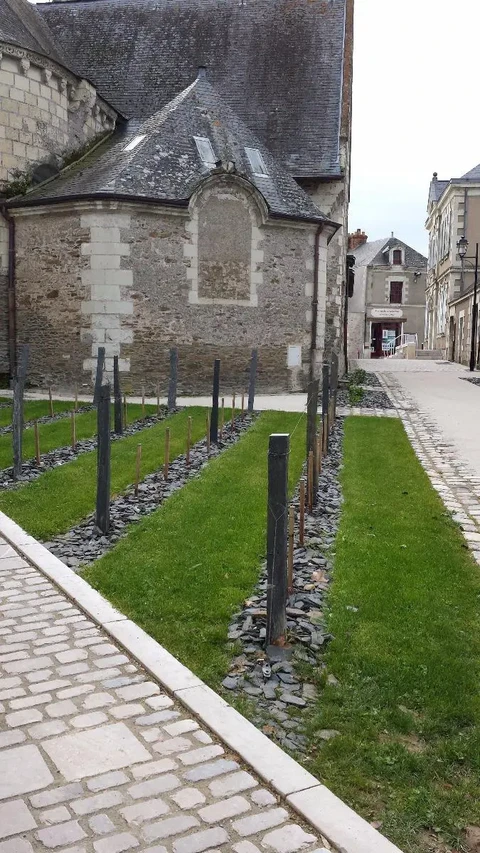Jardin contemporain aménagé contre une église en pierre de taille, style médiéval français