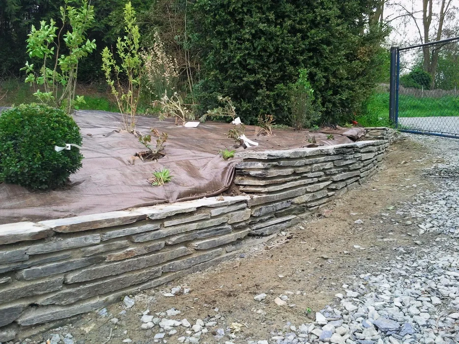 Jardin paysager m&eacute;diterran&eacute;en avec all&eacute;e courbe pav&eacute;e en b&eacute;ton et briques rouges