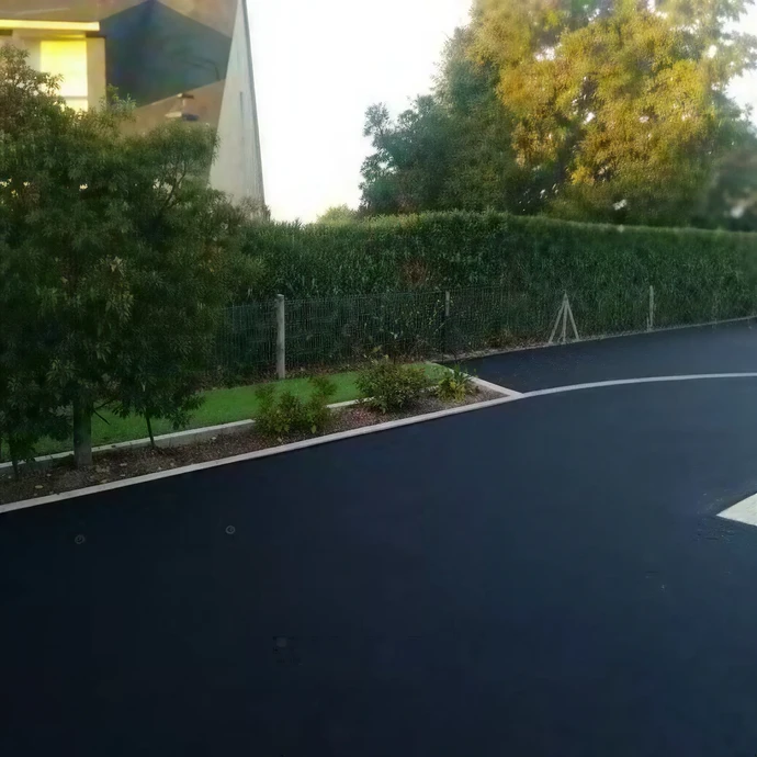 Parking extérieur avec rangée de véhicules neufs alignés sur pavés, éclairage naturel diurne