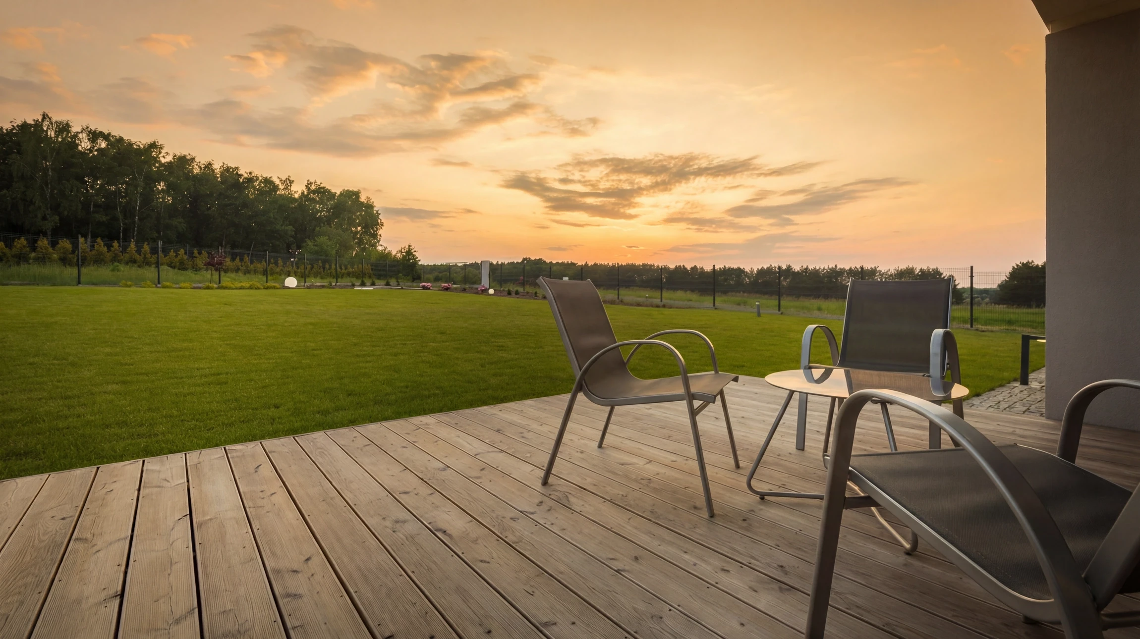 Jardin paysager extérieur avec terrasse en bois composite, mur de briques rouges en arrière-plan